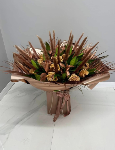Bronzed Luxe - A striking contemporary gift bouquet presented in a coordinating gift box and wrapped in luxurious bronze-toned packaging, finished with elegant ribbon detailing. Showcasing a sophisticated palette of warm champagne, bronze, rich brown, and fresh green accents, this design combines bold textures with modern styling for a truly distinctive presentation. Perfect for milestone birthdays, corporate gifting, anniversaries, congratulations, or anyone who appreciates contemporary elegance, this arrangement makes a memorable statement with its refined, earthy charm.
