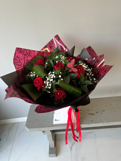 6 Red Roses - A luxurious hand-tied bouquet of 6 red roses wrapped in elegant black and crimson patterned packaging and finished with flowing satin ribbons.