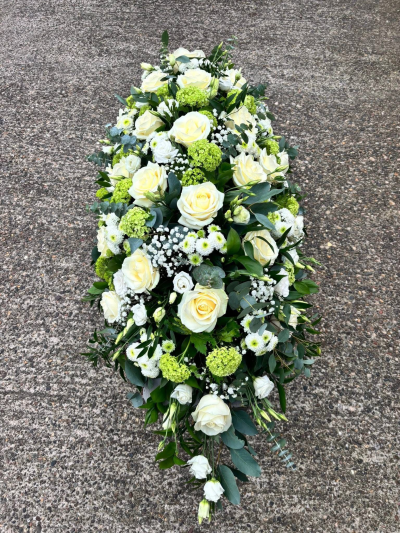 Peaceful Grace Spray - A beautifully crafted full-length casket spray designed in an elegant palette of ivory, crisp white, soft green, and lush foliage. With its natural flowing shape, abundant textures, and timeless styling, this heartfelt tribute symbolises peace, hope, and everlasting remembrance. Thoughtfully arranged to honour the memory of a loved one, it offers a comforting expression of sympathy and respect, creating a serene and dignified centrepiece for funeral and memorial services.
