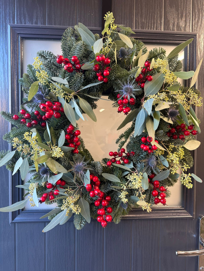 Winter Berry - Celebrate the festive season with the timeless beauty of the Winter Berry Elegance Wreath. Handcrafted using fresh evergreen foliage, this luxurious design is accented with vibrant red berries, soft silvery greenery, and natural botanical textures for a classic woodland finish. Perfect for welcoming guests throughout Christmas, this elegant wreath brings a fresh, sophisticated touch to any front door and complements both traditional and contemporary décor.