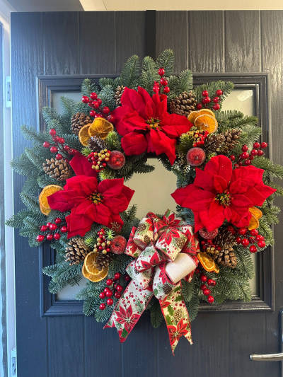 Traditional Christmas - Celebrate the festive season with the timeless elegance of the Traditional Christmas Welcome Wreath. Handcrafted with fresh evergreen foliage, this classic design features vibrant red festive accents, natural pine cones, dried citrus slices, decorative berries, frosted seasonal ornaments, and a beautifully patterned festive bow. Rich in traditional colours and rustic charm, this wreath creates a warm, inviting entrance and is the perfect finishing touch for your Christmas décor.