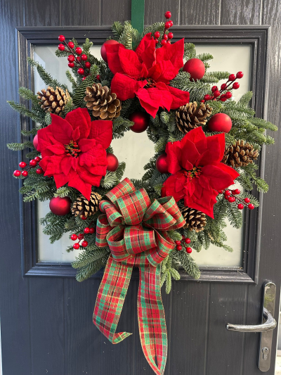 Traditional Tartan - Celebrate the season with the timeless charm of the Traditional Tartan Christmas Wreath. Handcrafted with fresh evergreen foliage, this classic design features rich red accents, natural pinecones, matte red baubles, and a luxurious tartan bow that brings warmth and heritage-inspired style to your home. Combining festive textures with traditional Christmas colours, this elegant wreath creates a welcoming display for your front door throughout the holiday season.